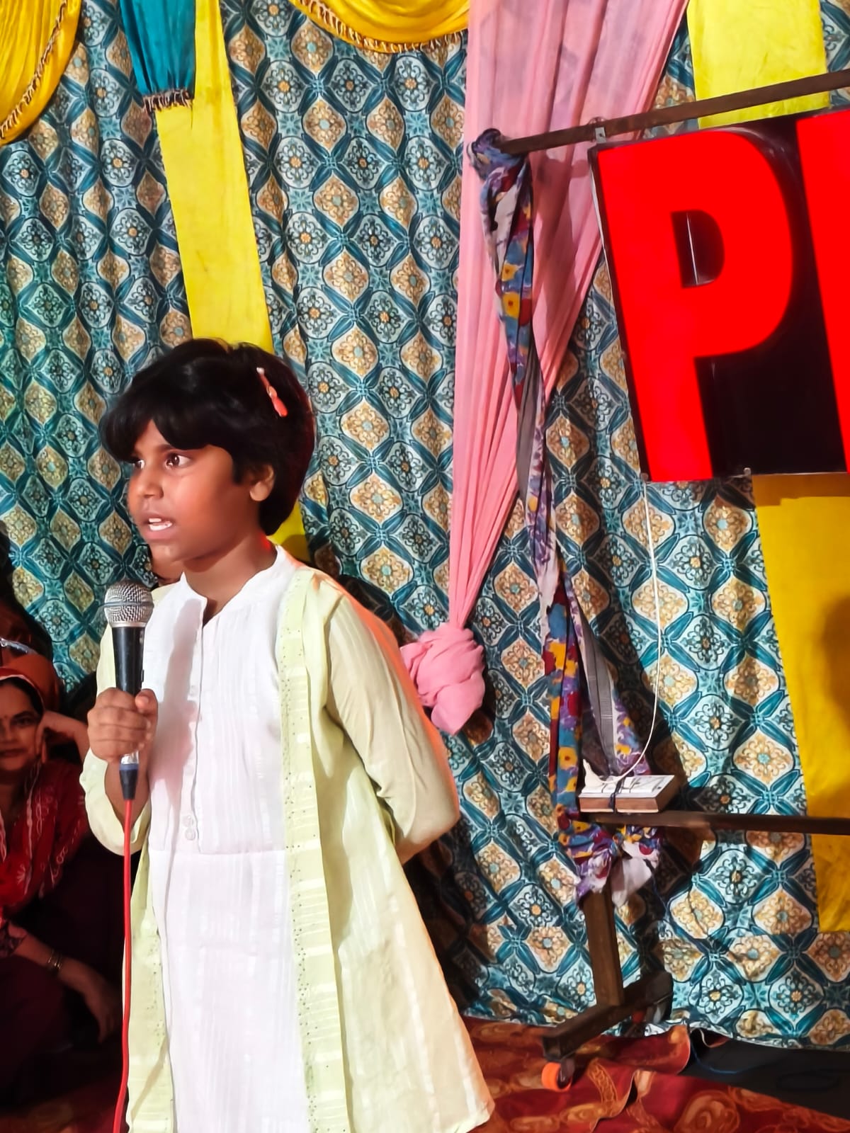 Student speaking on stage during Annual Day