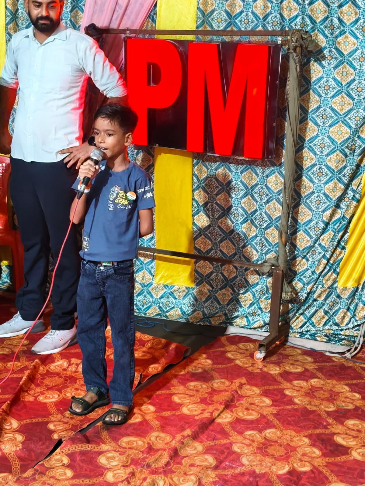 Student speaking on stage with a teacher